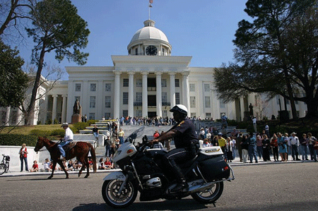 An Alabama policeman rides in front of the state capitol building in Montgomery. Alabama's new immigration law will force police will be forced to become immigration agents. (Flickr/AlphachimpStudio)
