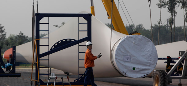 Workers prepare to lift a giant blade to be used as part of wind turbines at the Vestas Wind Technology Co. Ltd. factory in Tianjin, China, on September 14, 2010. The Chinese central government committed to increase renewable energy consumption to 11.4 percent of the energy mix by 2015 and 15 percent by 2020. (AP/Ng Han Guan)