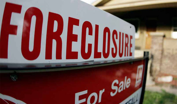 A foreclosure sign tops a sale sign outside an existing home on the market in northwest Denver. (AP/David Zalubowski)