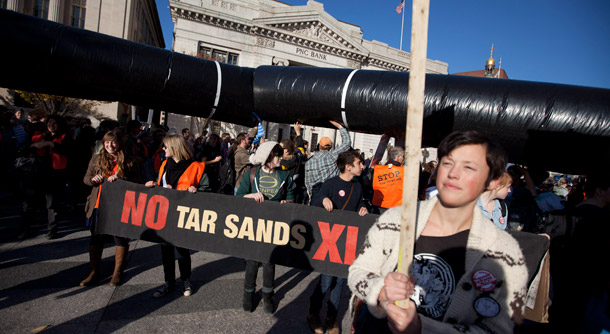 Demonstrators march with a replica of a pipeline during a protest to demand a stop to the Keystone XL tar sands oil pipeline outside the White House on November 6, 2011, in Washington. People of faith joined in the opposition to the pipeline. (AP/Evan Vucci)