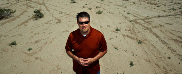 Bureau of Land Management Renewable Energy Project Manager Greg Helseth stands on the Roach Dry Lake bed in front of a proposed solar energy site near McCullough Pass, Nevada. (AP/Laura Rauch)