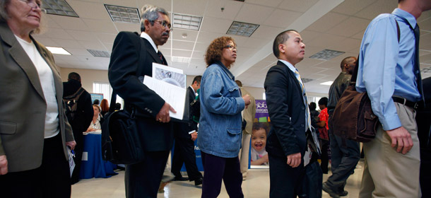 Job seekers line up to speak with participating employers during a jobs fair at Roxbury Community College in Boston on October 7, 2011. Failure to extend the payroll tax cut and emergency unemployment benefits by December 31 raises our risk of slipping back into recession. (AP/Michael Dwyer)