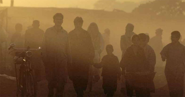 People walk through the Afghan enclave of Katchi Abadi near Islamabad, Pakistan. One aid group working in the region only accepts small U.S. government grants instead of larger, multiyear ones because doing so means they can avert the need to collect personnel information, which can undermine relationships with local communities. These programs, however, can have less of an impact because they reach less people and run for a shorter time period. (AP/Laura Rauch)