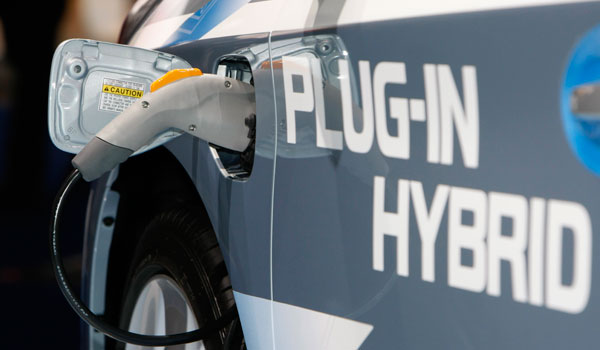 The plug to charge the batteries is plugged in to a Toyota Prius Plug-In Hybrid on the first press day of the Frankfurt Auto Show in 2009. (AP/Thomas Kienzle)
