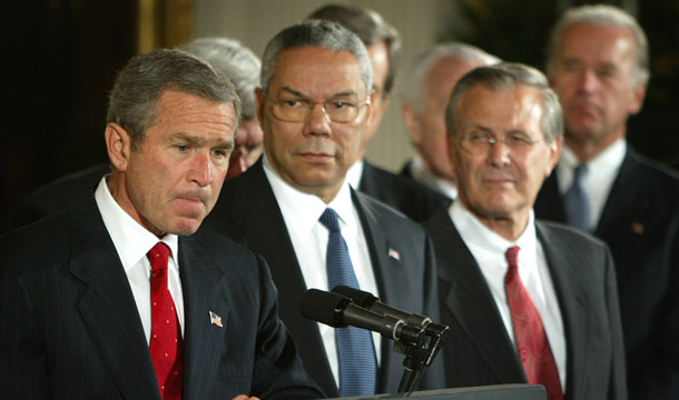 President George W. Bush, left, standing with Secretary of State Colin Powell, center, and Secretary of Defense Donald H. Rumsfeld, right, pauses as he speaks before signing a resolution authorizing the use of force against Iraq, Wednesday, October 16, 2002. (AP/Ron Edmonds)