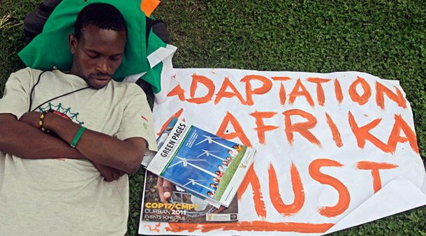 A protester rests next to his banner in Durban, South Africa, on November 29, 2011, on the second day of the two-week U.N. climate conference. Consistent funding for developing countries to adapt to climate change will be critical over the next decade. (AP/Schalk van Zuydam)