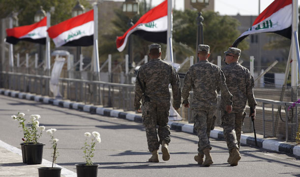 Iraqi flags wave as U.S. soldiers leave Al Faw palace at Camp Victory, one of the last American bases in Iraq, after a special ceremony in Baghdad, Thursday, December 1, 2011. (AP/Khalid Mohammed)