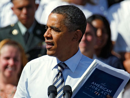 President Barack Obama holds a copy of the American Jobs Act as he talks about passing the bill. (AP/Ed Andrieski)