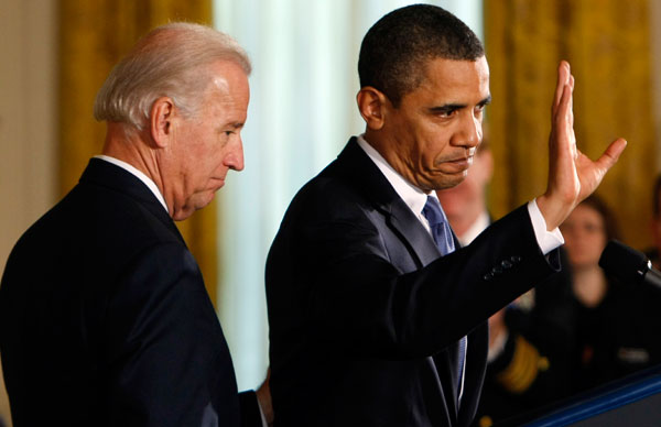 President Barack Obama, accompanied by Vice President Joe Biden, waves after signing the National Defense Authorization Act for Fiscal Year 2010.  (AP/Gerald Herbert)