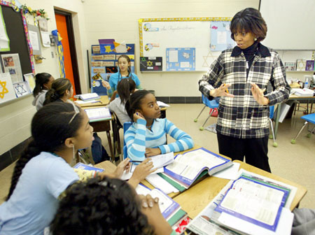 Vernestine Strickland, an eighth-grade teacher at Gwynn Park Middle School, in Clinton, Maryland, talks with Ashlei Gray, left, and Simone Hoggs about classroom schoolwork. (AP/Matt Houston)