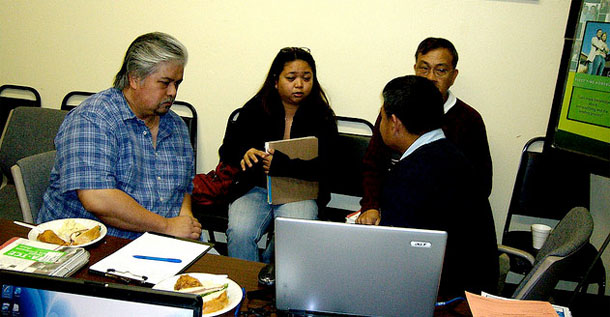 Volunteers from the National Asian American Coalition help a man and a woman with special credits such as the earned income tax credit and child tax credit. With<i> </i>one in five eligible taxpayers not claiming the earned income tax credit<i>, </i>volunteers can play a major role in raising awareness<i>.</i> (Flickr/<a href=