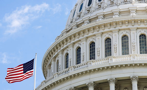 An American flag waves outside the U.S. Capitol Building, where elected officials will have to work together to help our economy grow and recover. (AP/Manuel Balce Ceneta)