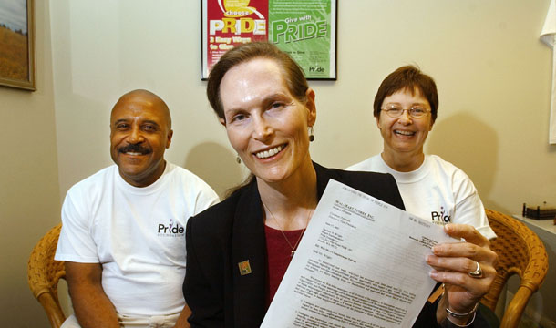Marsha Botzer, a board member of the gay advocacy group Pride Foundation, sits with foundation employees Jeffrey Hedgepeth, left, and Sara Elward as she displays a letter they received from Wal-Mart Stores, Inc. Many companies of all sizes, including Wal-Mart, have incorporated sexual orientation and gender identity into their employment nondiscrimination policies. (AP/Elaine Thompson)