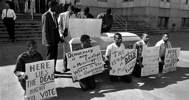 Demonstrators, who identified themselves as members of the Committee on Appeal for Human Rights, gather around an open casket containing a copy of the 15th Amendment on the steps of the Atlanta, Georgia post office, March 30, 1963. (AP)