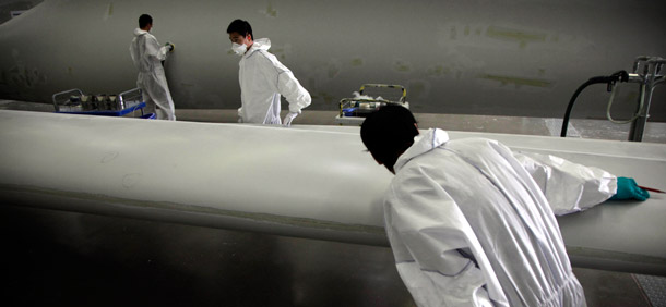 Workers examine giant blades to be used as part of wind turbines at the  Vestas Wind Technology (China) Co. Ltd. factory in Tianjin, China. As the world’s fastest- and largest-growing energy market, China is an  ideal testing ground for scaling up and commercializing clean energy  technologies. (AP/Ng Han Guan)