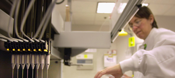 Vickie Chaplin loads patient samples into a machine for testing at Myriad Genetics in Salt Lake City. A new report shows the rapidly expanding genetic and genomic clinical laboratory  testing industry in the United States currently supports 116,000 jobs  and $16.5 billion in national economic output. (AP/Douglas C. Pizac)