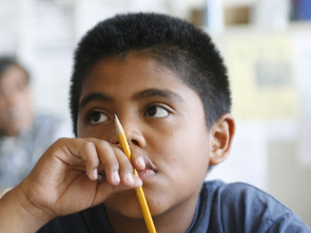 Jonathon Martínez, 12, hace un trabajo para la escuela en las oficinas de Hermandad Mexicana, un centro comunitario para los inmigrantes hispanos en Lynwood, California. (AP/Damian Dovarganes)