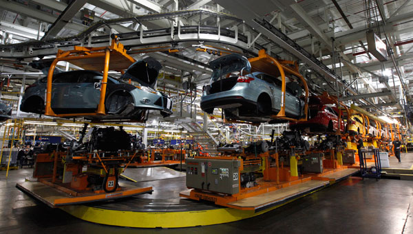 Ford Focus vehicles move on the assembly line at the Ford Michigan Assembly plant in Michigan. U.S. factories roared to life in December, creating sharply more goods to meet strong demand for business equipment, materials, vehicles and energy.
(AP/Paul Sancya)