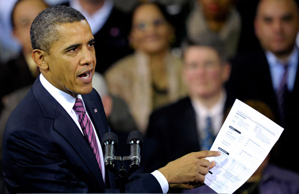 President Barack Obama holds up a proposed mortgage application form as he outlines his administration's proposal to allow homeowners with privately held mortgages to take advantage of record low rates for an annual savings of about $3,000 for the average borrower. (AP/Cliff Owen)