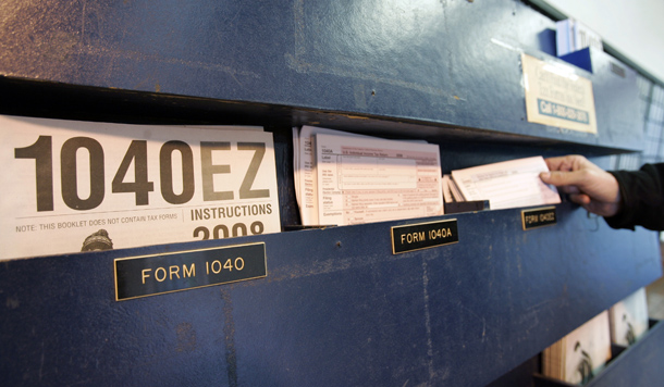 A man picks up a federal tax form at a post office in Palo Alto, California, Wednesday, April 15, 2009. (AP/Paul Sakuma)