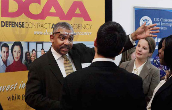 Defense Contract Audit Agency recruiters Gregory Brooks and Jarolyn Snyder, second from right, talk with job fair participants during a 2009 job fair at Roosevelt University in Chicago.
<br /> (AP/Charles Rex Arbogast)