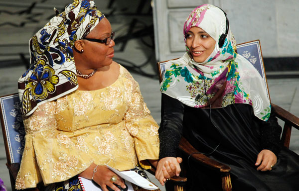 Nobel Peace Prize winner and Liberian peace activist Leymah Gbowee, left, holds hands with fellow prize winner Tawakkol Karman of Yemen during the 2011 Nobel Prize ceremony in Oslo, Norway.
<br /> (AP/John McConnico)