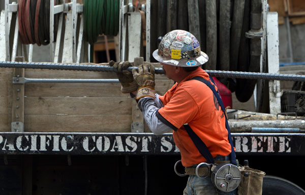 An ironworker carries steel rods for a retaining wall at a construction site in Los Angeles, California. U.S. employers added 227,000 jobs in February to complete three of the best months of hiring since the recession began.
  (AP/Damian Dovarganes)