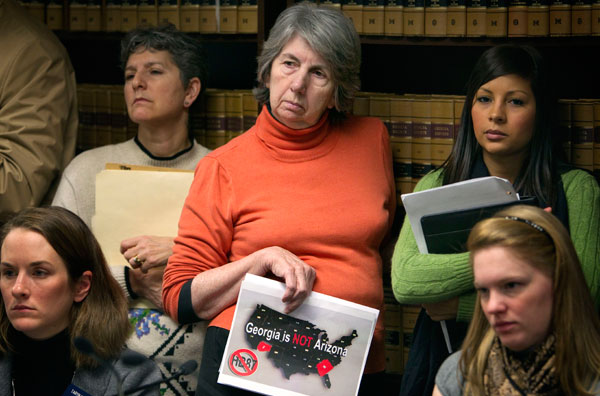 Mary Jean Goode, of Dunwoody, Ga, center, holds a sign opposing H.B. 87 to crack down on illegal immigration during a hearing in February 2011 in Atlanta.
(AP/David Goldman)