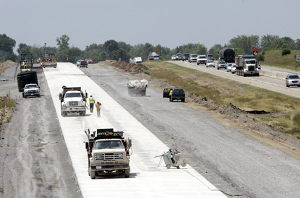 State crews in 2006 work on rebuilding a highway in Michigan. Potholes, congestion, and lack of repairs to aging roads and bridges all make driving a source of frustration, which is why infrastructure spending is so vital to our economy. (AP/Carlos Osorio)