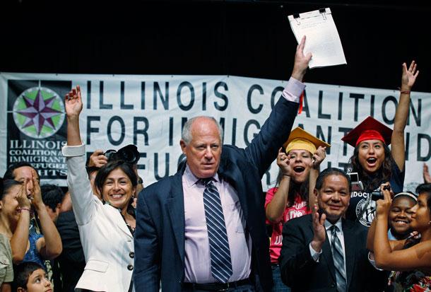 Gov. Pat Quinn celebrates with students and supporters after signing the Illinois DREAM Act into law on August 1, 2011. (AP/ M. Spencer Green)