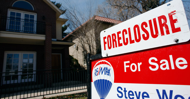 A foreclosure sign sits atop a for sale sign in front of a single-family home tops the for sale sign in Denver. The government-controlled mortgage giant Fannie Mae and its regulator, the Federal Housing Finance Agency, last week announced pilot programs as the first step in a major strategy to convert foreclosed homes to rentals. (AP/David Zalubowski)