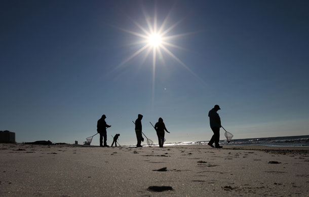 The RESTORE Act represents a tremendous step toward rebuilding the Gulf Coast region and diversifying the states’ economies, which were devasted by the Deepwater Horizon oil catastrophe. Above, cleanup crews search for oily tar balls along the beach in Gulf Shores, Alabama in 2011. 
  (AP/ Dave Martin)