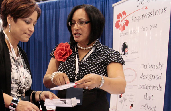 Empresaria Ivette Mayo, a la derecha, le habla a un cliente en la convención del U.S. Hispanic Chamber of Commerce en Florida. Las mujeres Latinas, propietarias de negocios, componen el segmento que crece con la mayor rapidez. (AP/Alan Diaz)