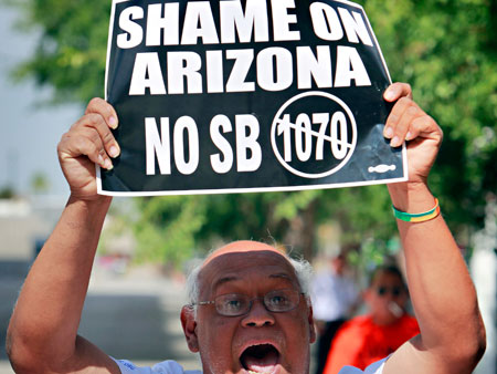 Paul Sanchez protests Arizona's anti-immigrant S.B. 1070 outside the Sandra Day O'Connor Federel Courthouse in Phoenix. This week the constitutionality of the law will be argued in front of the Supreme Court. (AP/ Matt York)
