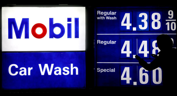A gas station attendant raises gas prices on a display at a Mobil gas station in Chicago, on April 6, 2012. (AP/ Nam Y. Huh)