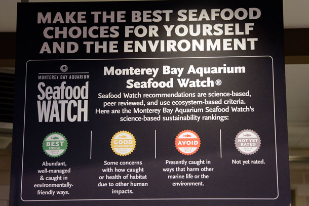 A "Seafood Watch" sign with a color-coded rating program hangs over the seafood counter in Whole Foods in Hillsboro, Oregon. (AP/ Rick Bowmer)