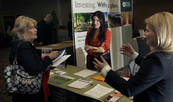 Iulia Petelea, right, and Carolina Baso, center, of International House, speak to a potential applicant during a job fair in Boston, Monday, April 2, 2012. (AP/Elise Amendola)