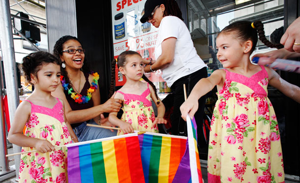 Jennifer Melendez, left, and her wife Juliza, standing, prepare for the annual 2011 New York Gay Pride parade with their daughters Natalia, left, Mahlani, center, and Alexis. Gay and transgender communities of color face higher levels of economic, educational, and health insecurities than their white and straight peers.<br /> (AP/Mark Lennihan)