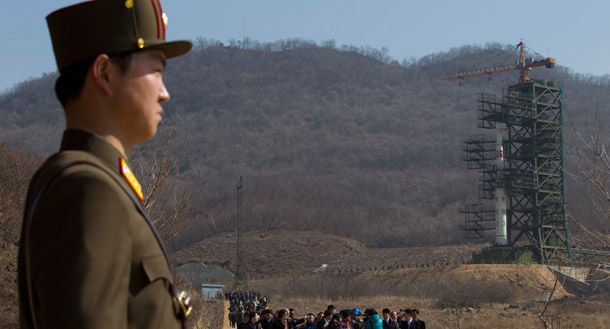 A crowd of media gather around an official on a road in front of the Unha-3 rocket at Sohae Satellite Station in Tongchang-ri, North Korea before liftoff on April 8, 2012. The rocket, which launched today, experienced a catastrophic system failure during the boost phase. (AP/David Guttenfelder)