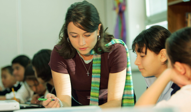 Valeri Kershaw, a seventh- and eighth-grade literacy teacher at Bruce Randolph Middle School in northeast Denver, works with 12-year-old Jessica Rodriguez during class, Thursday, October 27, 2005. Statistics show that women are more likely to work in low-wage, “pink-collar” jobs like teaching. (AP/David Zalubowski)