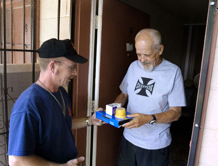 Doug Lilly of Meals on Wheels delivers a meal to Ted Jenson, 73, in Modesto, California. House conservatives are prepared to cut programs for low- and middle-income Americans, including Meals on Wheels, in order to protect unnecessary defense spending. (AP/ Al Golub)
