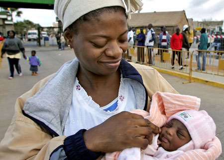 A woman holds her two-day-old baby in front of a refugee camp near the  wired zone that divides Morocco from the Spanish enclave of Melilla. Maternal mortality claims   the lives of nearly a thousand women every day. Nearly all of these   deaths happen in the developing world. (AP/Alvaro Barrientos)