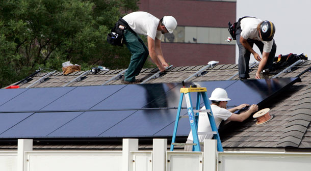 Workers with Namaste Solar Electric install solar panels on the Carriage House at the governor's mansion in Denver. (AP/ Ed Andrieski)