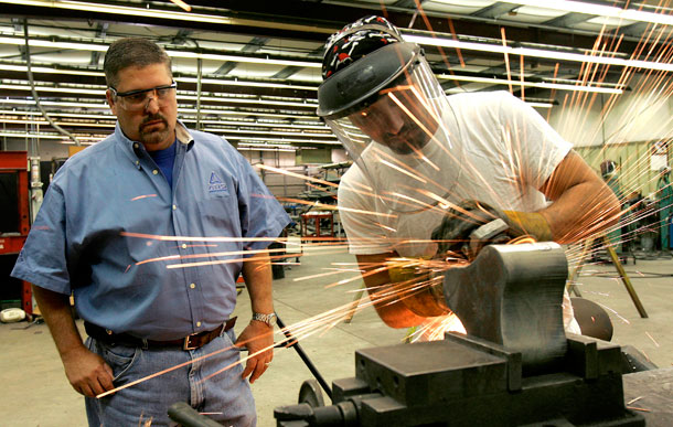 James Sellers, left, vice president of AUS Manufacturing Co., watches one of his employees, Jimmy Payne, grind a piece of equipment at the plant in Bonifay, Florida. (AP/ Phil Coale)