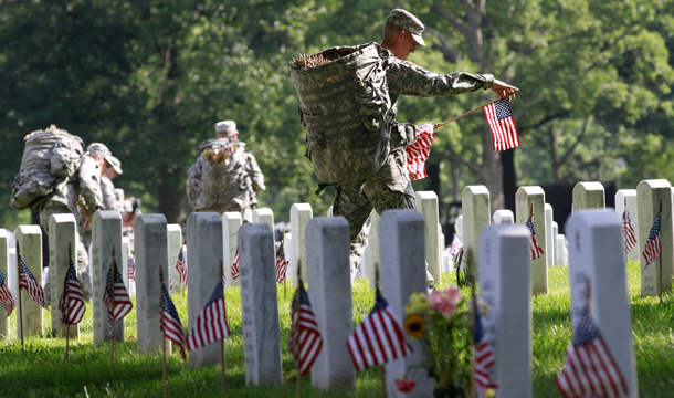 Army Sgt. Brian Ellis, 22, of Canyon Lake, Texas, places a flag before each grave in preparation for Memorial Day, during the annual "Flags-In" at Arlington National Cemetery in Arlington, Virginia, on Thursday, May 24, 2012. (AP/Jacquelyn Martin)