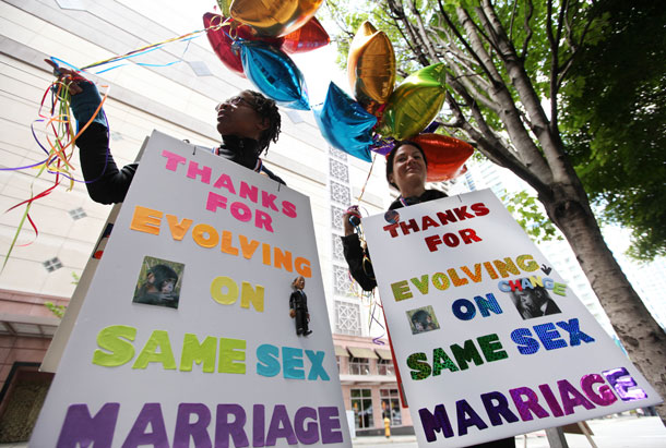 Marriage equality supporters Teri McClain, left, and Mary Beth Brotski stand with signs supporting President Barack Obama outside a fundraising event for the president in Seattle. (AP/ Elaine Thompson)