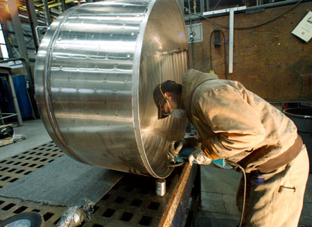 Chris Keltz polishes a tank at JV Northwest in Canby, Oregon. Since bottoming out in early 2010, the country has added back 4.2  million private-sector jobs, and is now into positive territory for President  Obama’s term. (AP/ Rick Bowmer)