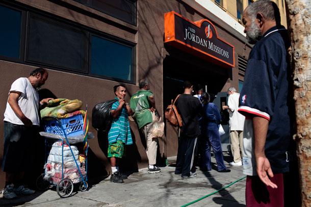 A group of homeless people wait in line outside a mission for food in Los Angeles. Homelessness is one of the issues Social Impact Bonds would attempt to target. (AP/ Jae C. Hong)