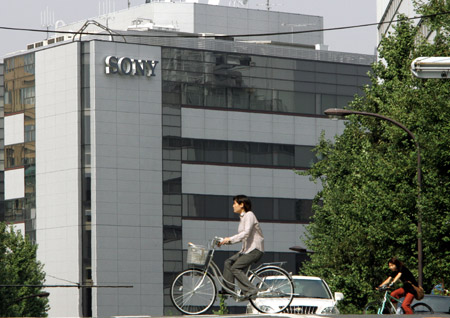 Women ride bicycles past Sony Corporation headquarters in Tokyo. The Trans-Pacific Partnership would benefit  well-known Japanese businesses such as Toyota and Sony and give U.S. businesses better access to Japanese markets. (AP/Katsumi Kasahara)