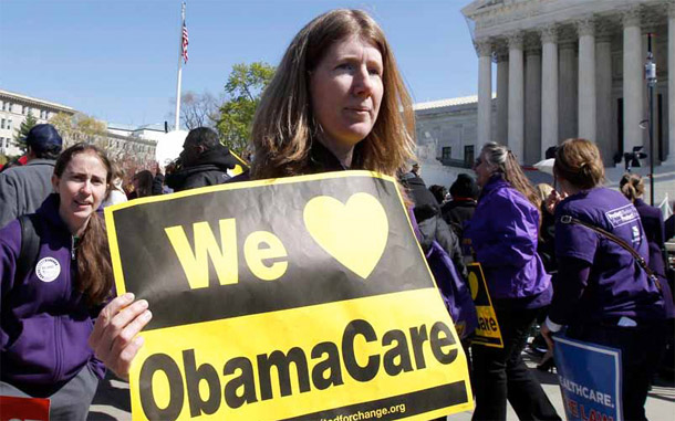 A woman holds up a sign in support of Obamacare in front of the Supreme Court in Washington as the Court debates the constitutionality of the health law on March 27, 2012. Health reform is critical for women. (AP/Charles Dharapak)